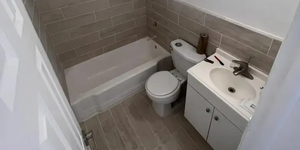Modern remodeled bathroom with new tiles, tub, and vanity in Miami.