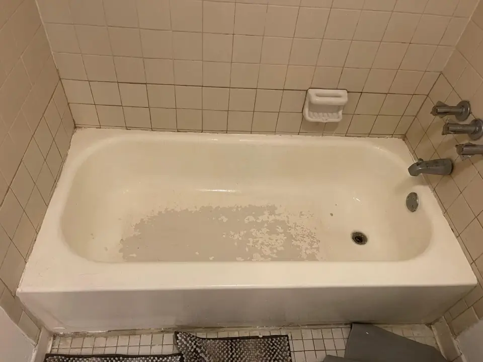 Before: Damaged bathtub with peeling surface before refinishing in Miami