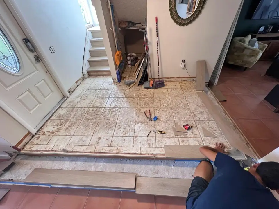 Before: Old tiled entryway before raised vinyl flooring installation in Miami home