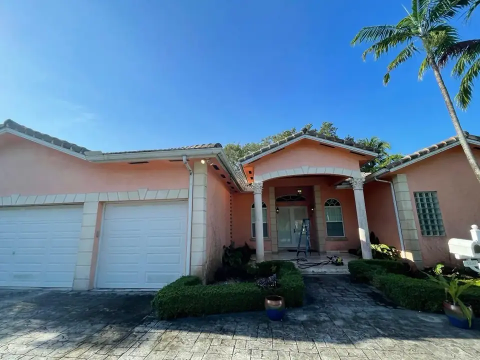 Before: Faded peach house exterior before painting in Miami