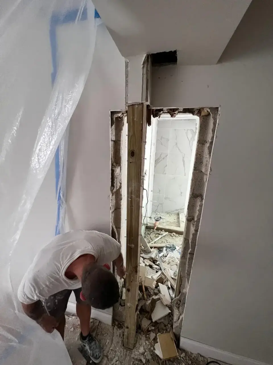 Removing wall during laundry to bathroom construction in Miami