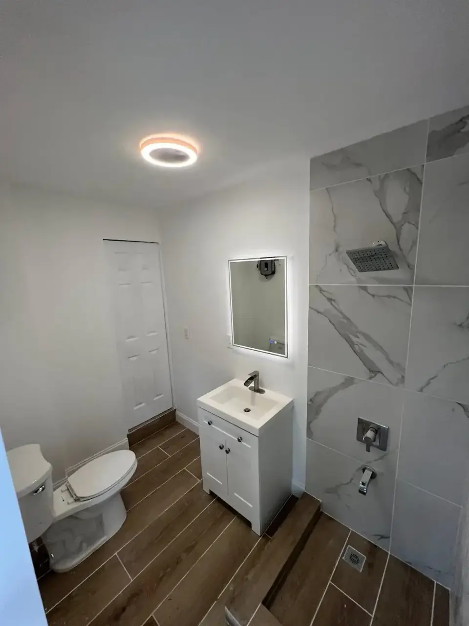 Now: Completed new bathroom with shower and vanity built from laundry space in Miami