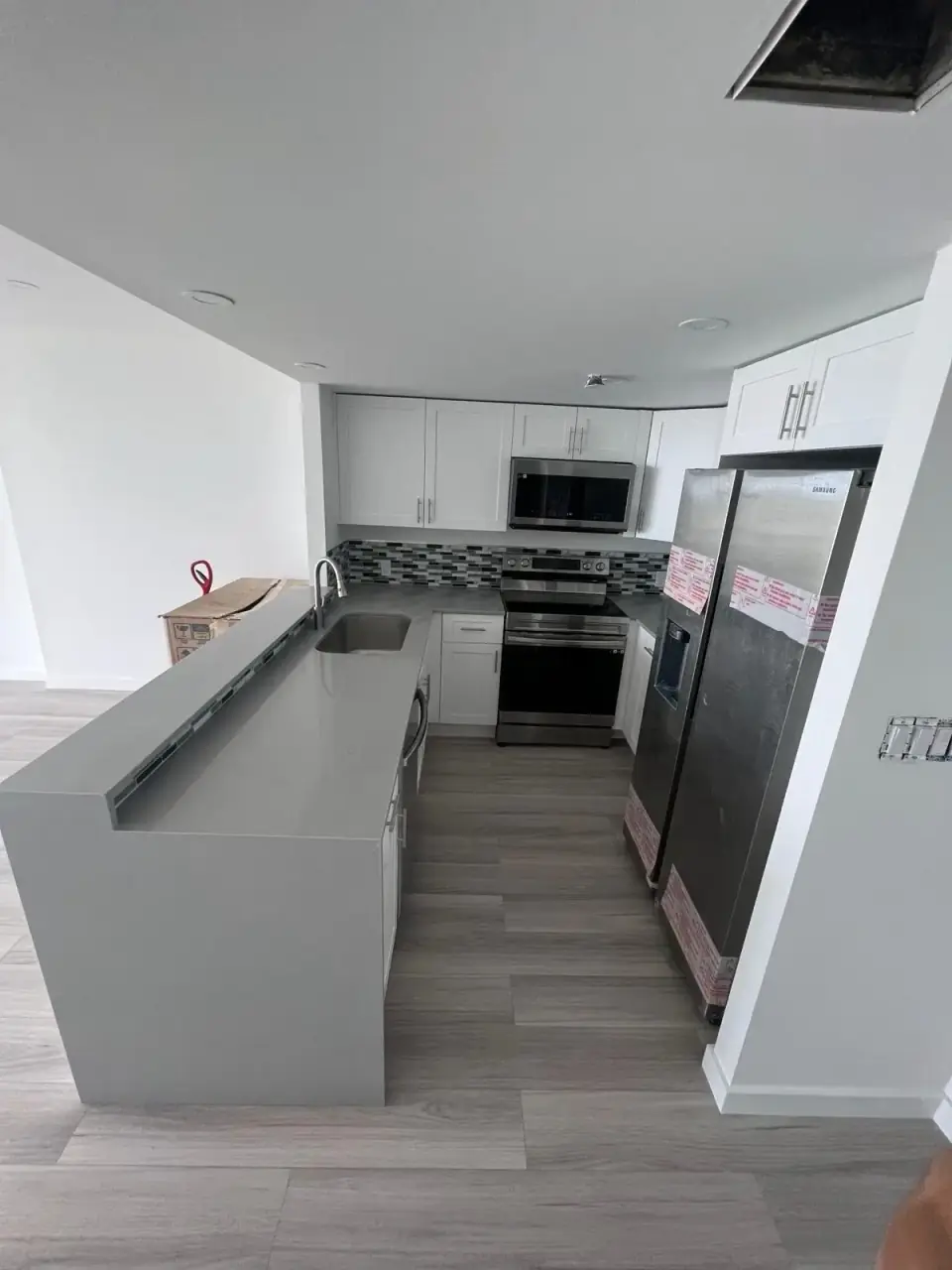 Now: Completed kitchen with modern finishes and appliances - side angle - Miami