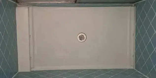 Finished shower floor repair with smooth white waterproof coating in Miami