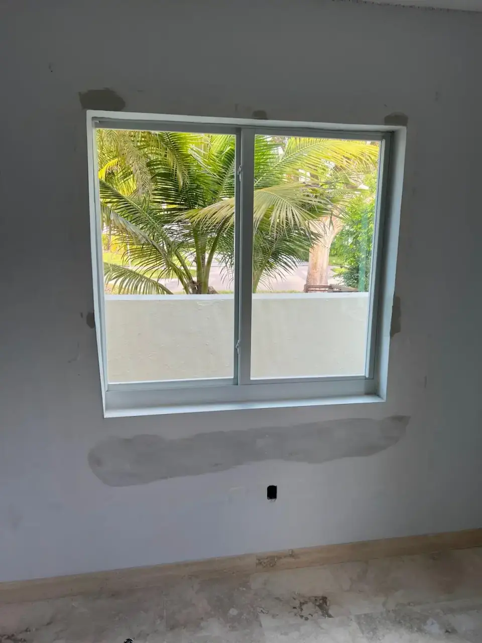 Window installation process with concrete repair and fresh framing in Miami